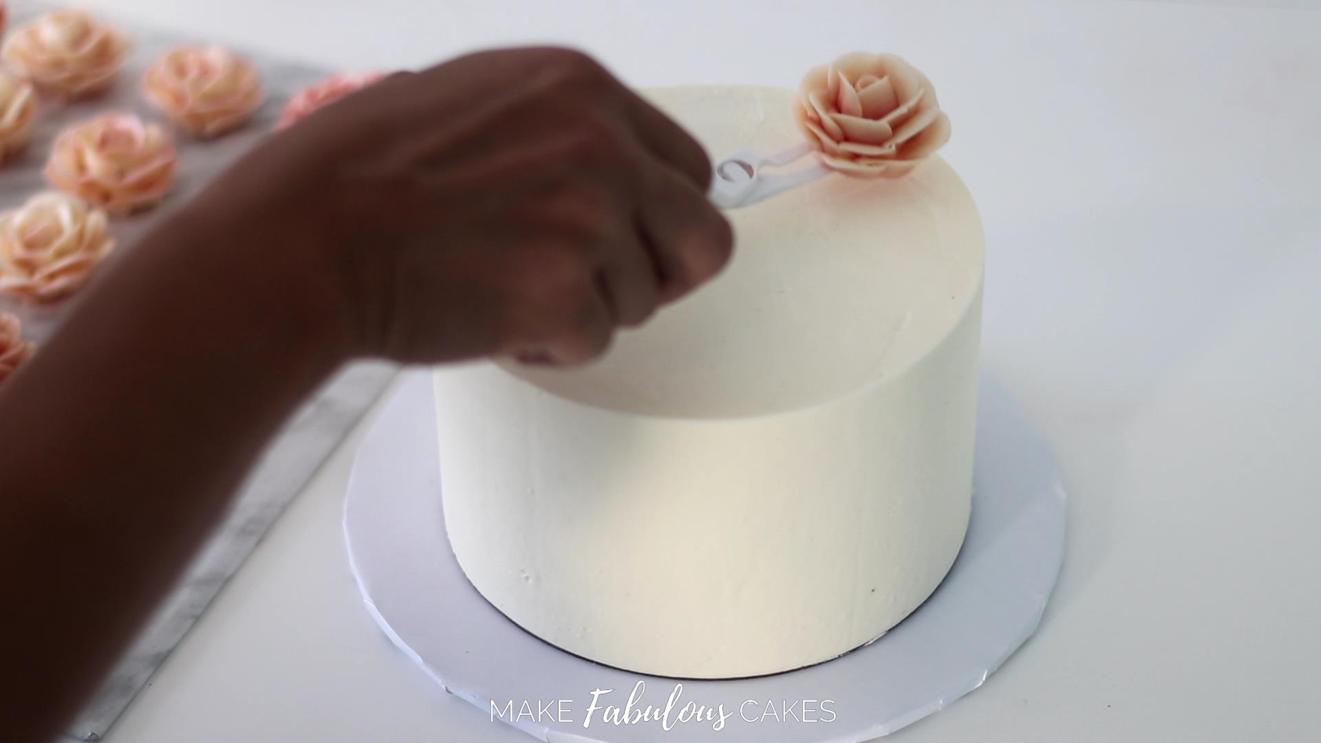 placing the buttercream roses on the swan cake