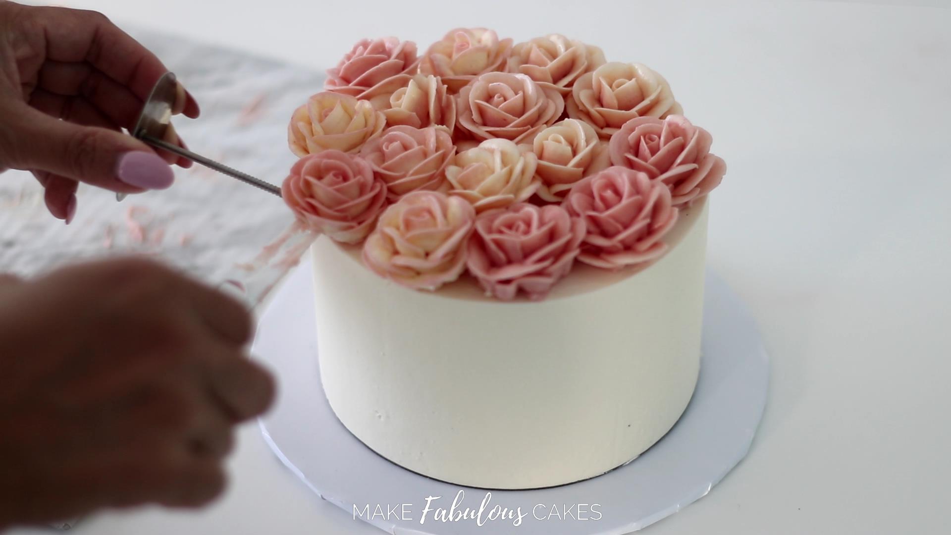 placing the buttercream roses on the swan cake