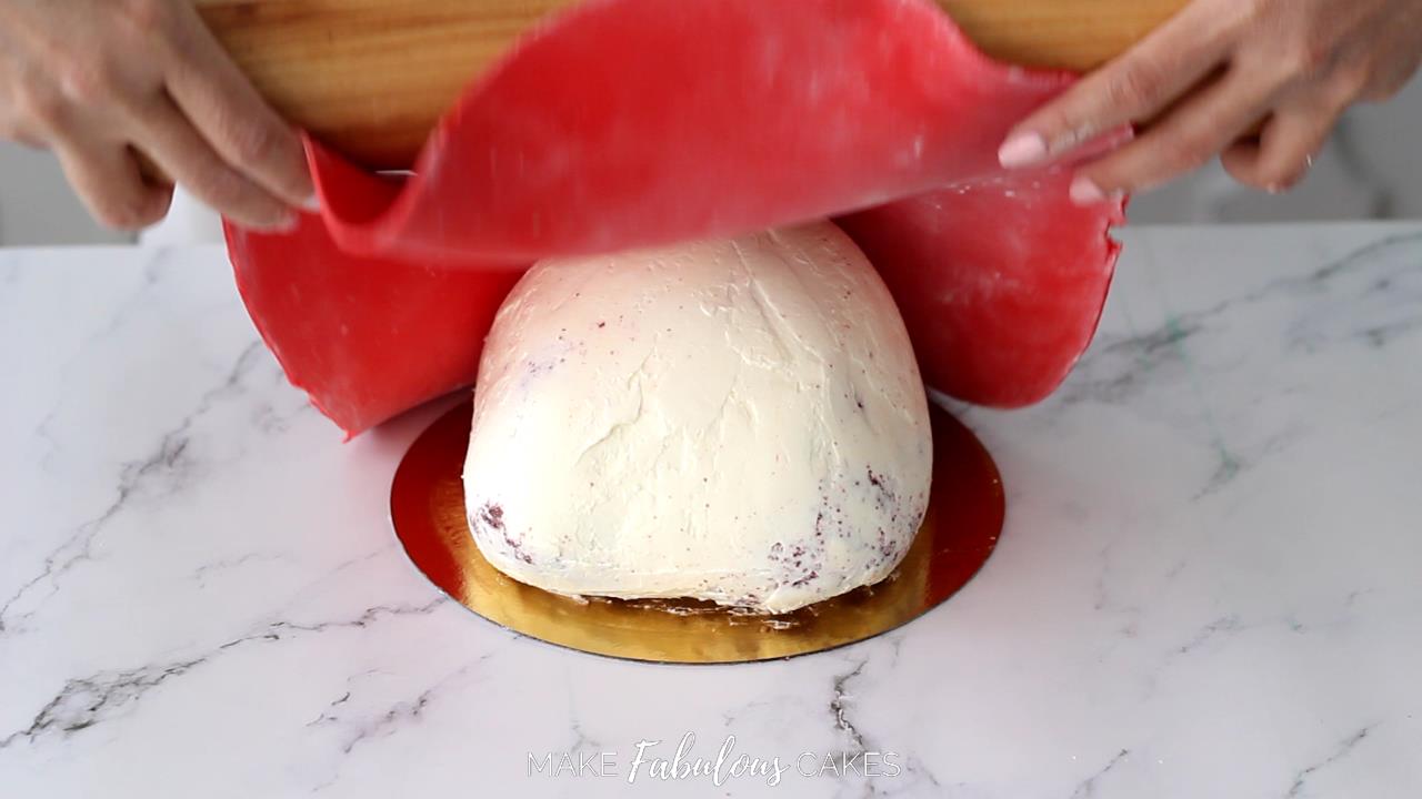 adding red fondant on mushroom cake top