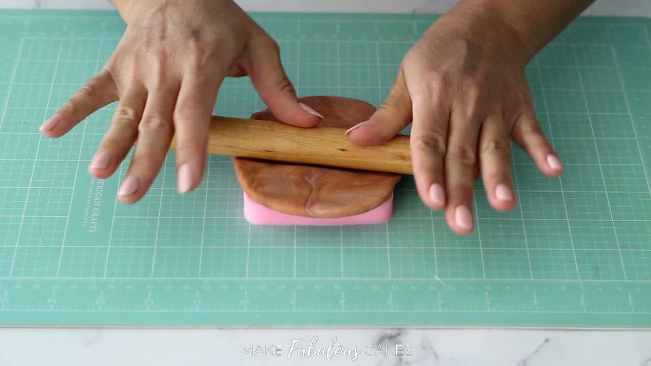 rolling the brown fondant over door silicone mold