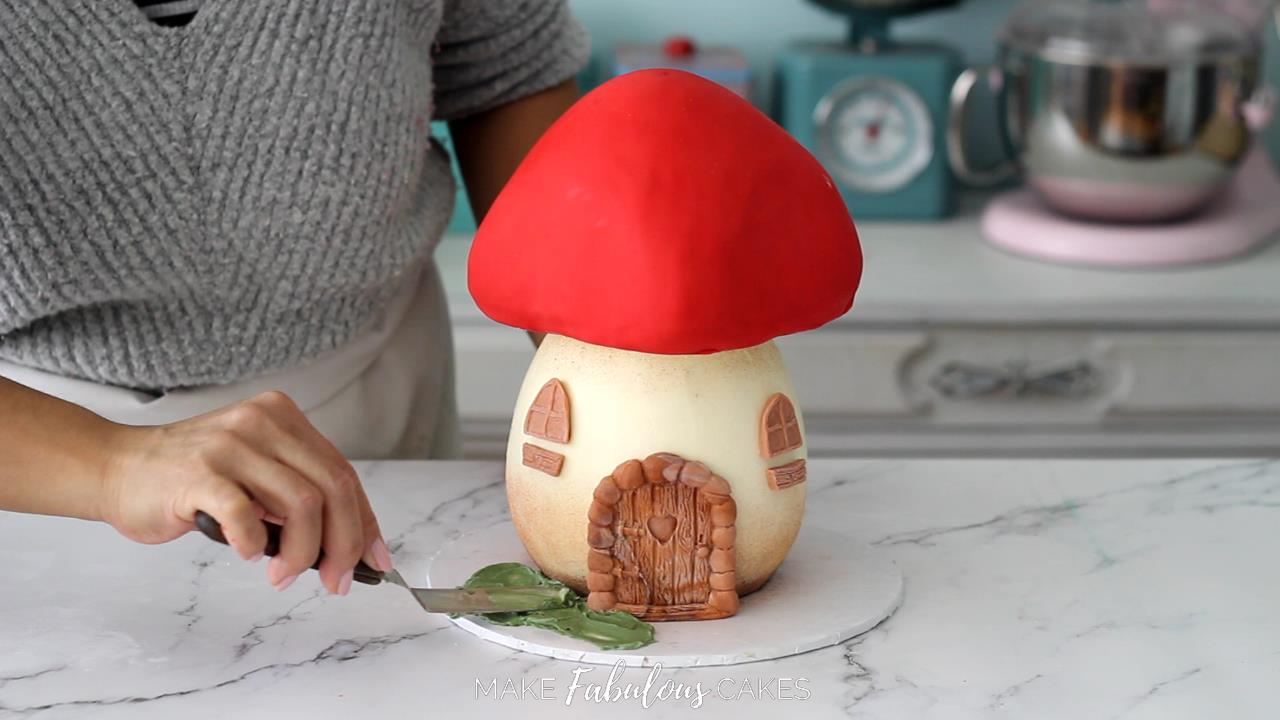 adding green buttercream on the cake board