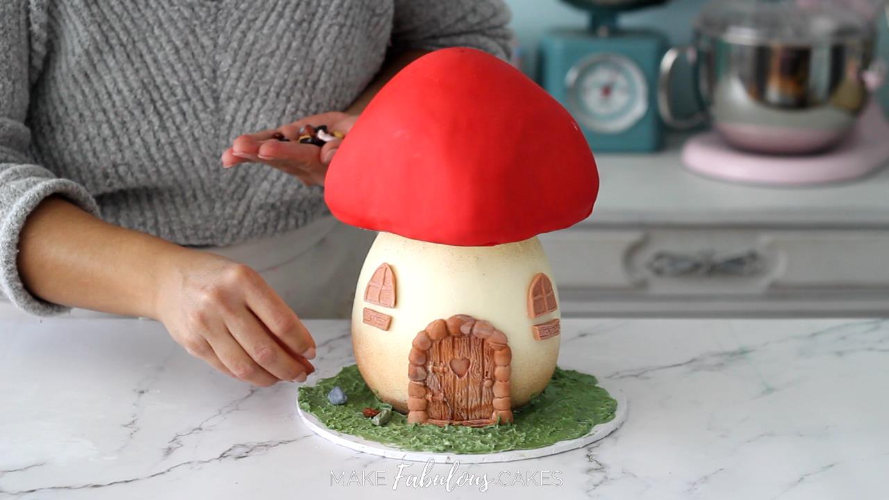 adding chocolate rocks on mushroom cake