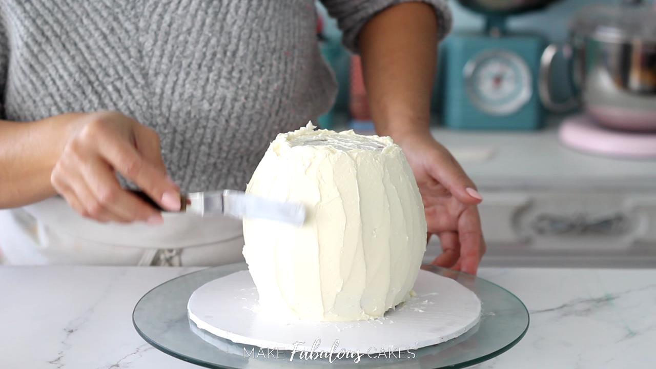 Frosting the mushroom cake base with small offset spatula