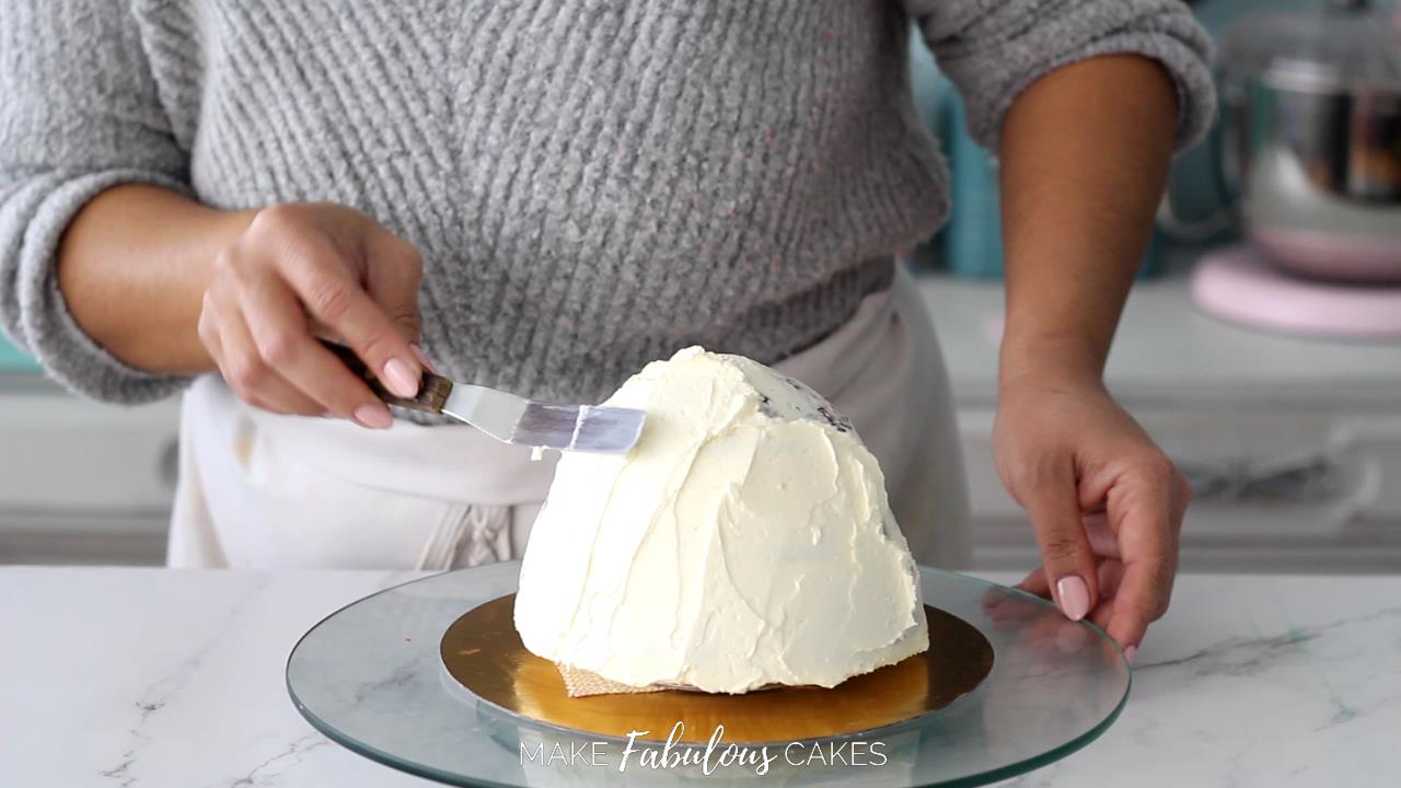 adding final coat of buttercream on the mushroom cap